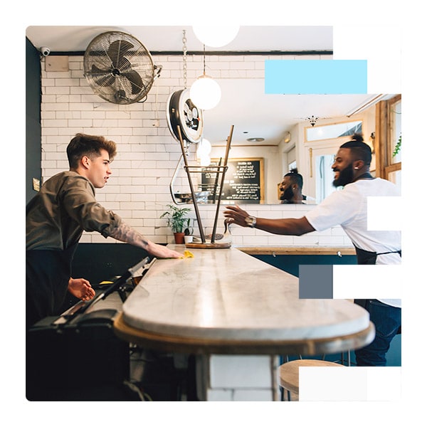 Two cafe workers talking over a counter